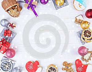 Christmas background. Christmas gift, toys, gingerbread cookies, spices and decorations on wooden background. Top view