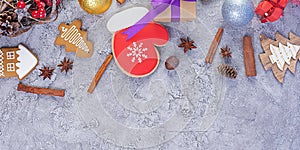 Christmas background. Christmas gift, toys, gingerbread cookies, spices and decorations on wooden background. Top view