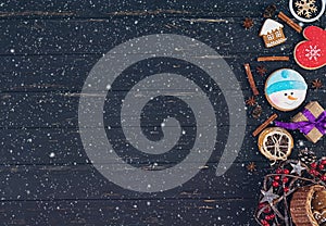 Christmas background. Christmas gift, toys, gingerbread cookies, spices and decorations on wooden background. Top view