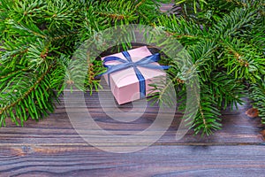 Christmas background with Christmas gift on wooden background with Fir branches. Xmas and Happy New Year composition. Flat lay, to