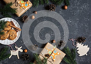 Christmas background. Christmas gifts, decorations, cookies, christmas tree. On a dark background, top view. Free space for text.