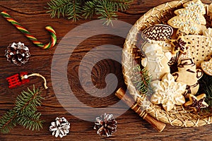 Christmas background: Christmas gingerbread, pine branches in decorative utensils, cones, candies on a wooden background, top view