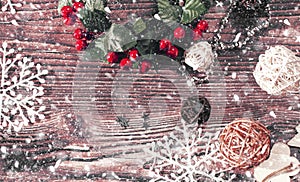 Christmas background of Christmas toys, spruce twigs,  snowflakes, stars, rattan balls and tinsel on a wooden brown table