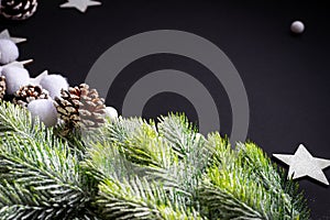 Christmas background. Christmas tree, cones and decoration stars. Christmas or New Year concept. Black background. Copy space