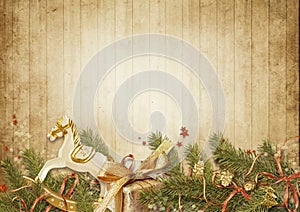 Christmas background. Christmas vintage card with holiday garland, gift and rocking horse on wooden background. Copy space