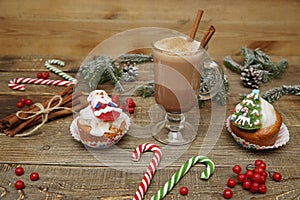 Christmas background with cocoa or hot chocolate, muffin or cupcakes with Santa Claus, snowman and Christmas tree, candy cane