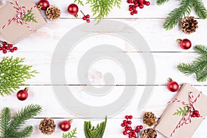 Christmas background concept. Top view of Christmas gift box with spruce branches, pine cones, red berries and bell