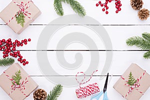 Christmas background concept. Top view of Christmas gift box with spruce branches, pine cones, red berries and bell