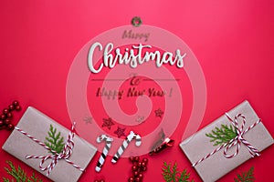 Christmas background concept. Top view of Christmas gift box with spruce branches, pine cones, red berries and bell on red