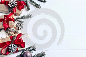 Christmas background concept. Top view of Christmas gift box with spruce branches, pine cones, red berries on white wooden table