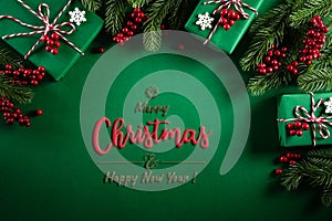 Christmas background concept. Top view of Christmas green gift box with decoration, spruce branches and red berries on green