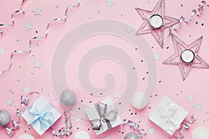 Christmas background with copy space for greeting text. Gift boxes and decoration on pink table top view. Flat lay.