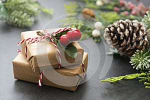 Christmas background with craft gift boxes, fir branches and pine cones. Winter holidays greeting card with present