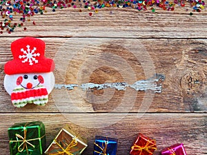 Christmas background decorations with Snowman and gift boxes on the old wood board by Flat lay, top view and copy space