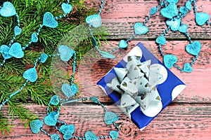 Christmas background with decorative christmas tree decorations blue beads , hearts, gift box, branches of christmas tree and