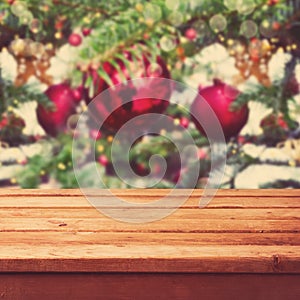 Christmas background with empty wooden deck table over Christmas tree decorations