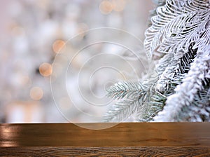 Christmas background. Empty wooden table on the background of a Christmas snowy branch . Ready for product montage. Banner.Mockup