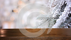 Christmas background. Empty wooden table on the background of a Christmas snowy branch . Ready for product montage. Banner.Mockup