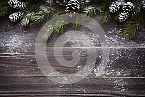 Christmas background with fir branches and cones and decorations on a dark wooden board. View from above. Space for copy