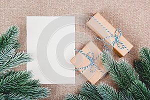 Christmas background with fir branches and gifts. Gift Boxes and blank paper sheet