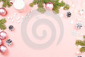 Christmas background with fir branches, lights, purple giftboxes, pink decorations, hot drink with marshmallows on pink