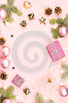 Christmas background with fir branches, lights, purple giftboxes, pink decorations, hot drink with marshmallows on pink