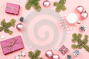 Christmas background with fir branches, lights, purple giftboxes, pink decorations, hot drink with marshmallows on pink