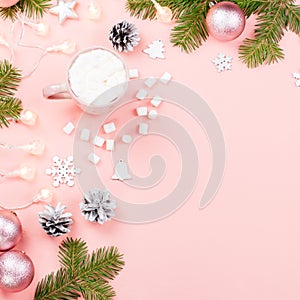 Christmas background with fir branches, lights, red giftboxes, pink decorations, hot drink with marshmallows on pink