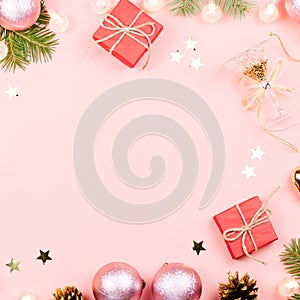 Christmas background with fir branches, lights, red giftboxes, pink decorations, hot drink with marshmallows on pink