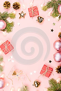 Christmas background with fir branches, lights, red giftboxes, pink decorations, hot drink with marshmallows on pink