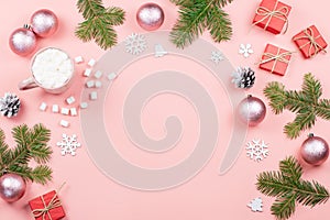 Christmas background with fir branches, lights, red giftboxes, pink decorations, hot drink with marshmallows on pink