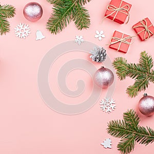 Christmas background with fir branches, lights, red giftboxes, pink decorations, hot drink with marshmallows on pink