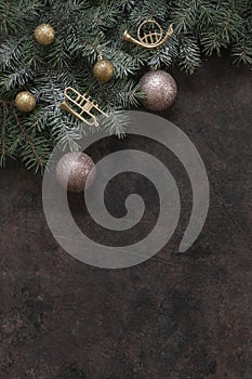 Christmas background with fir tree branches and golden color Christmas decoration â€“ balls, trumpets. Top view, close up