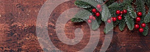 Christmas background with fir tree branches and holly. Top view. Horizontal banner. Copy space