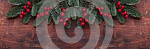 Christmas background with fir tree branches and holly. Top view. Horizontal banner. Copy space