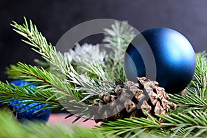 Christmas background. Fir tree and a christmas blue baubles over wooden board