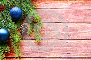 Christmas background. Fir tree and a christmas blue baubles over wooden board