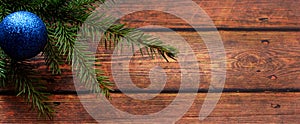 Christmas background. Fir tree and a christmas blue baubles over wooden board. banner