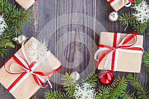 Christmas background with fir tree and decorations and gift boxes on wooden board