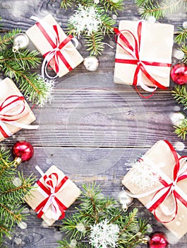 Christmas background with fir tree and decorations and gift boxes on wooden board decorated with snow