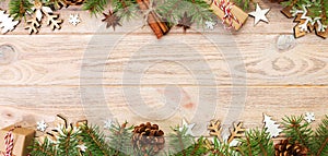 Christmas background with fir tree and gift box on wooden table. Top view banner with copy space for your design