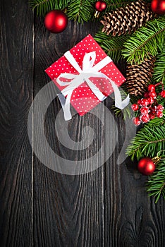 Christmas background with fir tree and red box present at dark