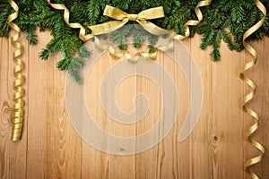 Christmas background with firtree, bow and ribbons on wood