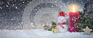 Christmas background with fourth Advent candle and Snowman with red decoration.