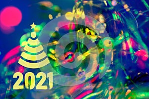 Christmas background-garlands with colorful lights on a decorated Christmas tree, bokeh, Happy New Year 2021 colored symbol and