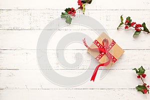 Christmas background with gift boxes, Christmas decorations and branches of holly and fir on white wooden background. Winter