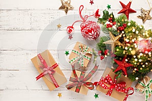 Christmas background with gift boxes, Christmas decorations and branches of holly and fir on white wooden background. Winter