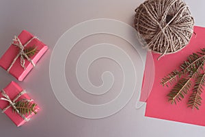 Christmas background with gift boxes, clews of rope, paper and decorations on red. Preparation for holidays
