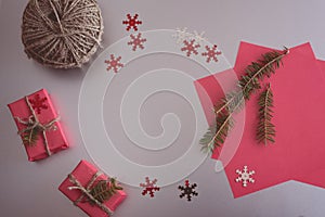 Christmas background with gift boxes, clews of rope, paper and decorations on red. Preparation for holidays