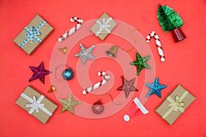 Christmas background with gift boxes, clews of rope, paper's rools and decorations on red. Preparation for holidays.